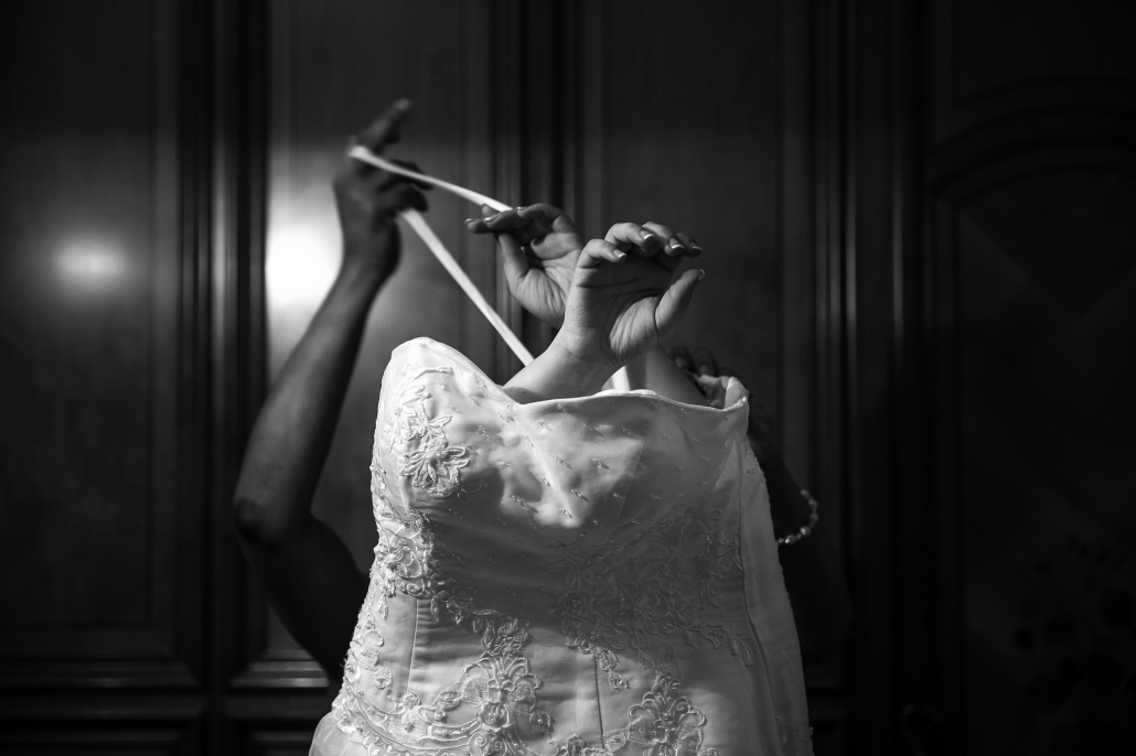 sposa durante la preparazione che indossa l'abito nuziale, scatto realizzato dal fotografo per matrimoni a milano bruno garreffa